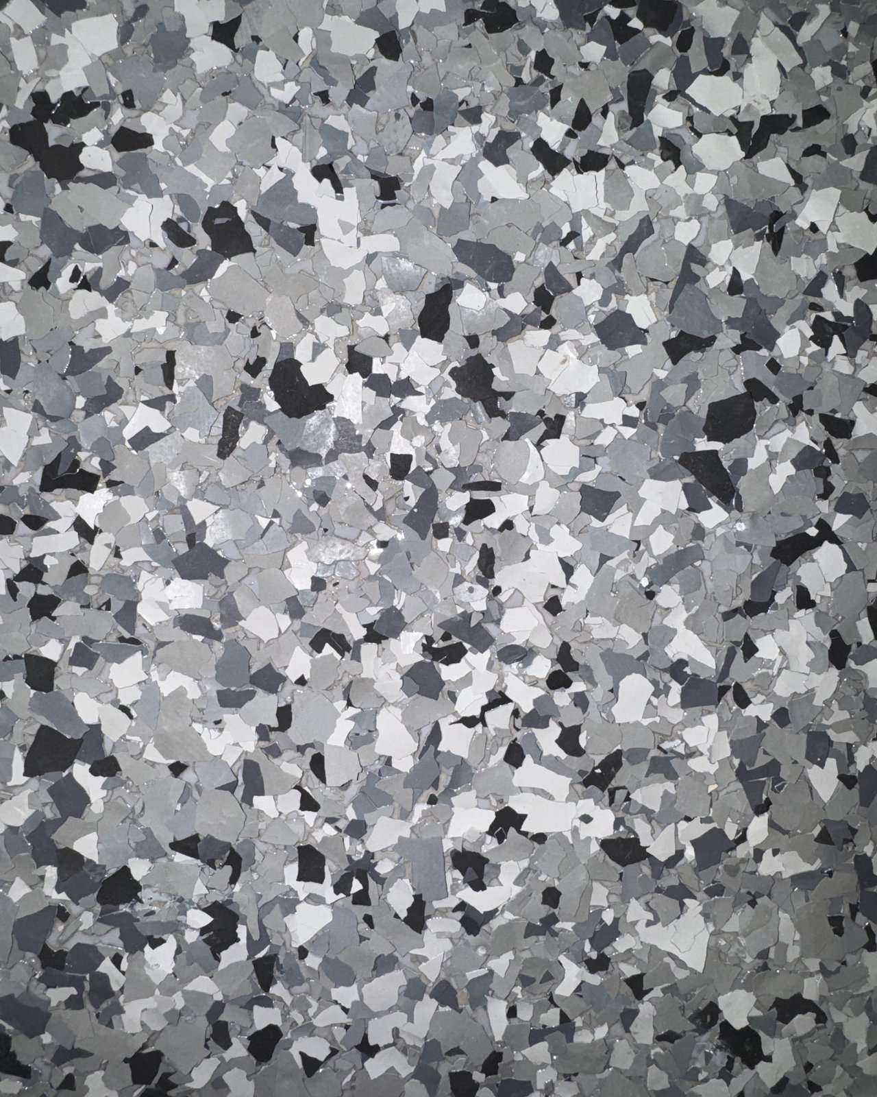 Close-up of a gray, black, and white full-flake polyaspartic floor finish
