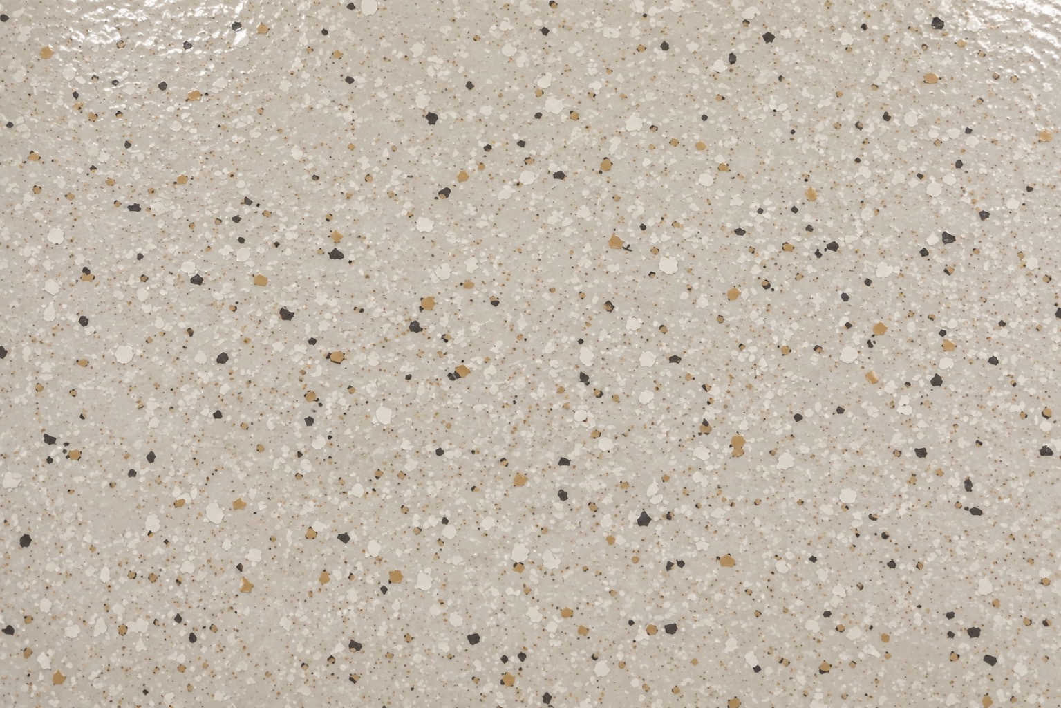 Close-up of a tan and cream flake-broadcast epoxy floor finish