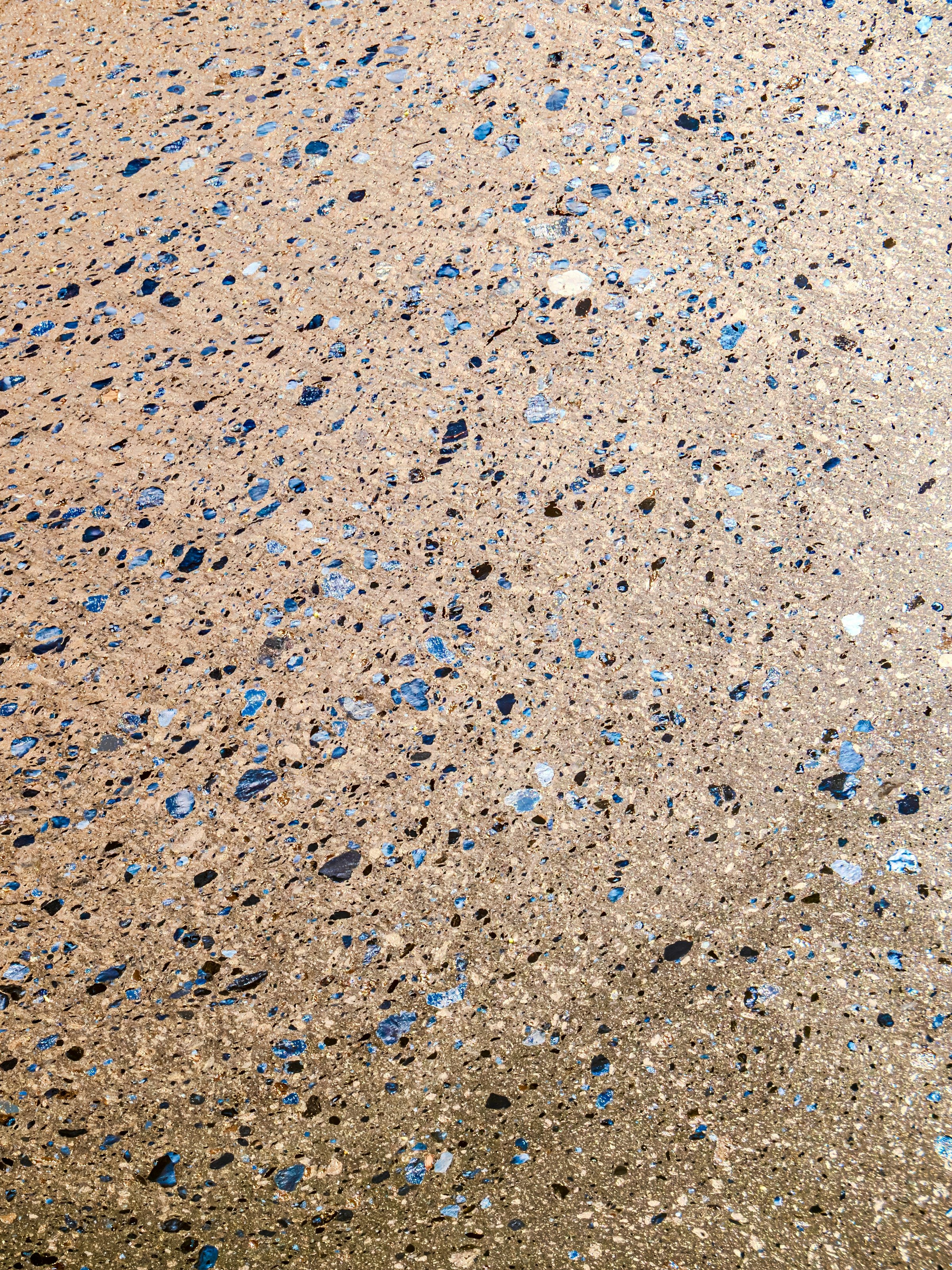 Close-up reference texture of blue and dark flake-broadcast resin floor