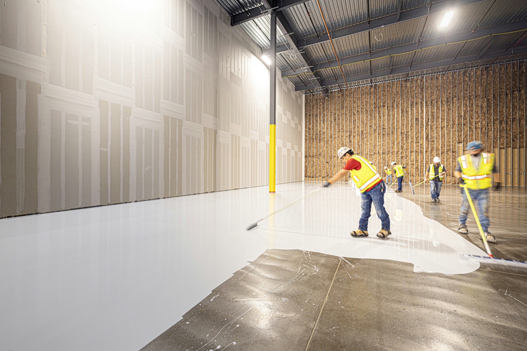 Installation crew applying a high-build floor coating